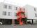 ３階建ての建物の１階部分に自動車が通過できるスペースが確保されている。建物の周囲は広くアスファルトで舗装してある。