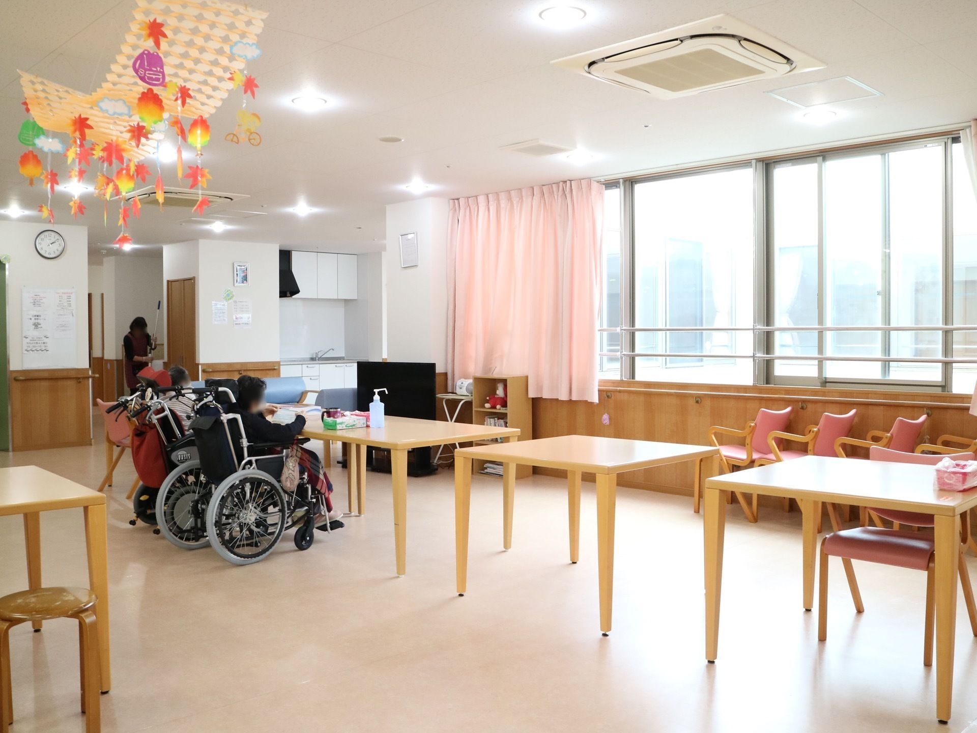 陽が明るく差し込み、やさしい木目の腰板が使われているリビング