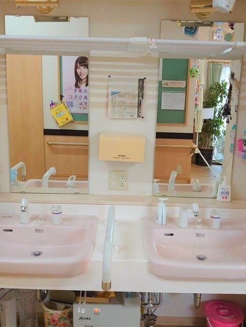 手すり付きの洗面台がならんでいる施設内の共有スペース内の様子