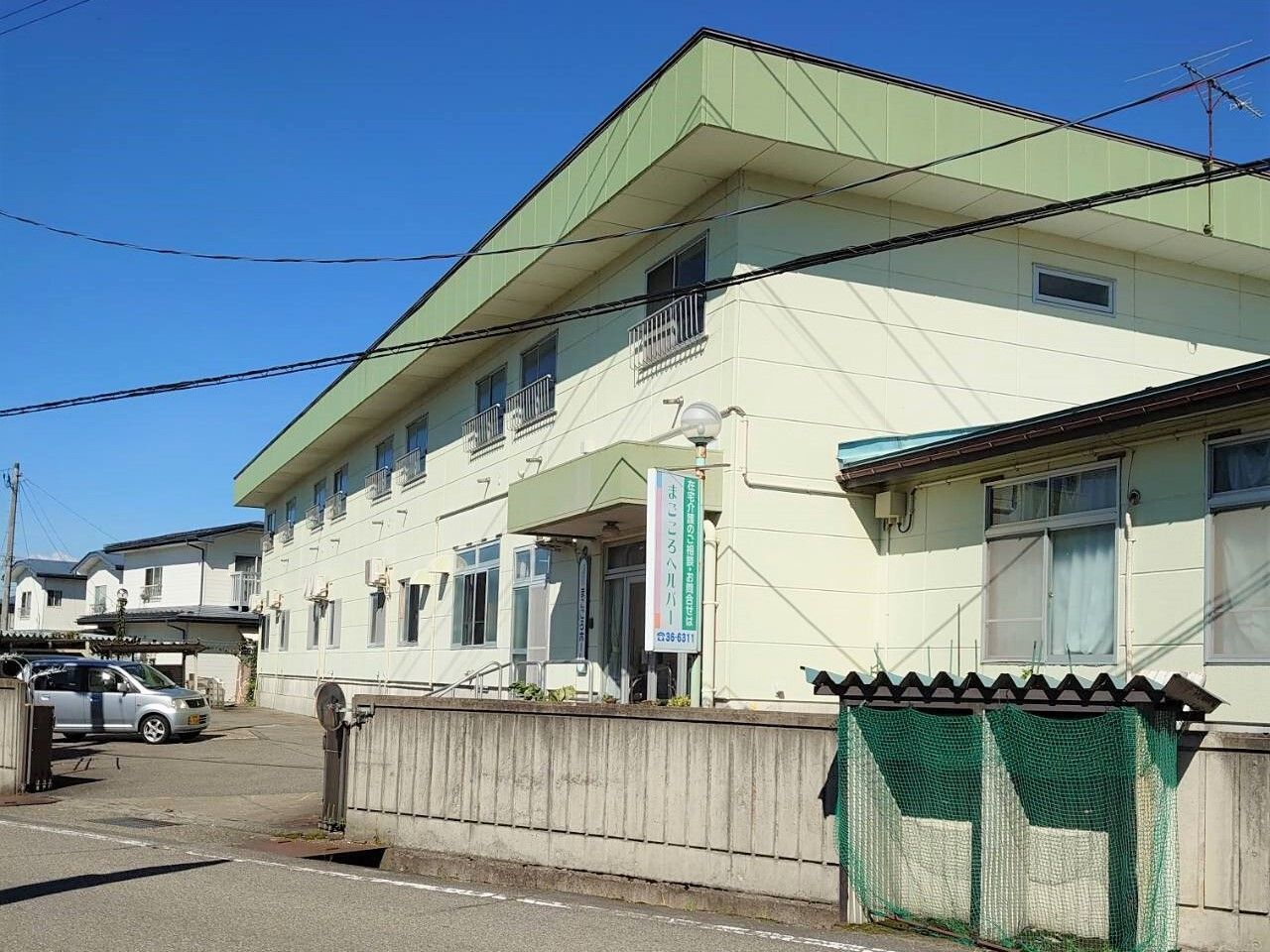 鏡を見ながら笑顔で話している高齢者とそこに寄り添介護スタッフの様子。明るい室内の写真