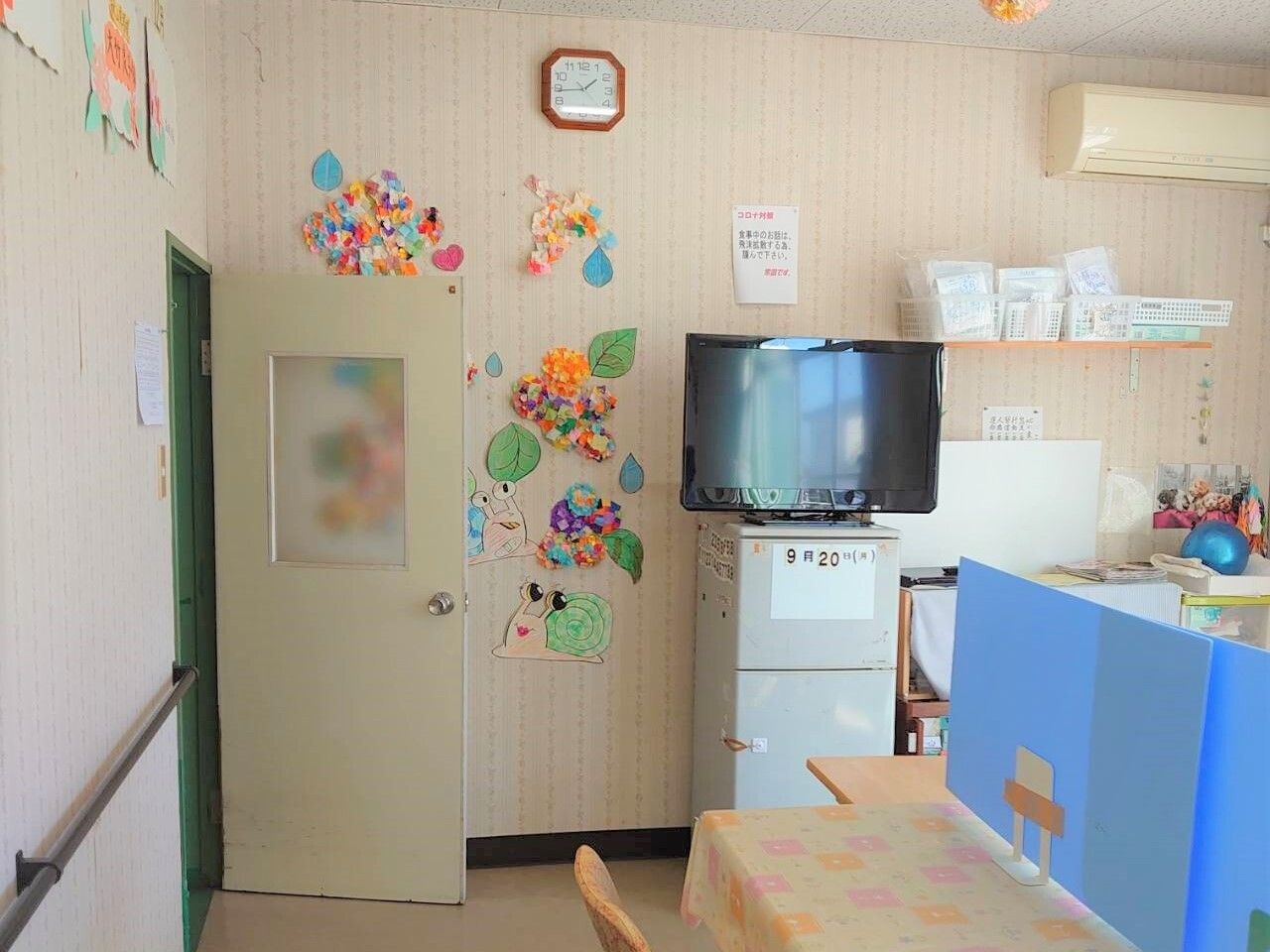 外に出て車いすの高齢者とスタッフが話している様子。笑顔で話している写真