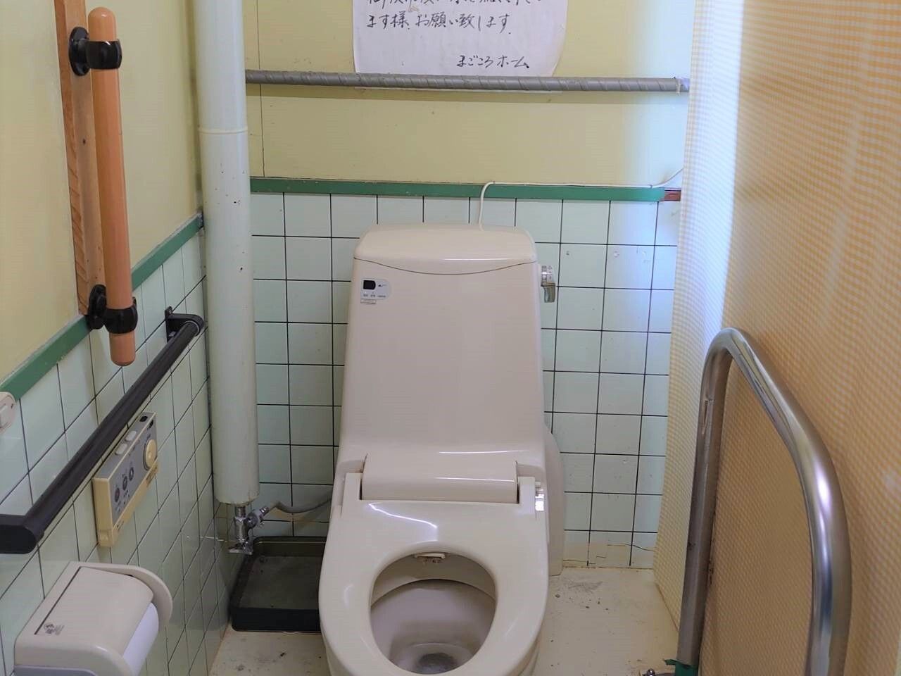 緊急コールと手すりが取り付けられているトイレの様子。施設内の設備の写真