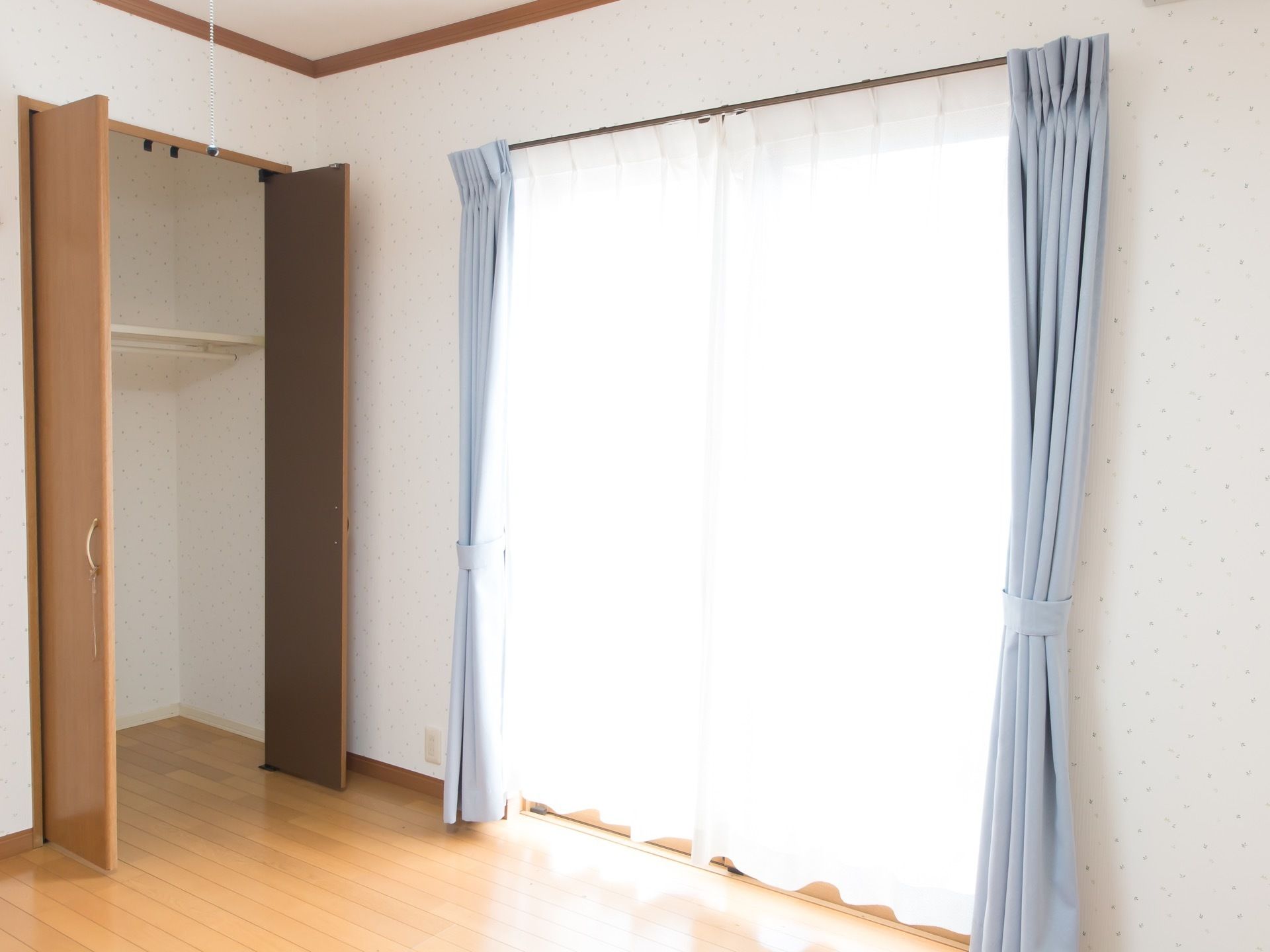 大きな窓からは日の光が差し込み明るい。窓にはブルーのカーテンが掛けられている。床はフローリングになっており、木の温もりを感じる。