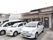 家庭的な雰囲気の2階建ての建物である。駐車場には車が3台停まっている。玄関扉には施設名が記されたステッカーが貼られている。