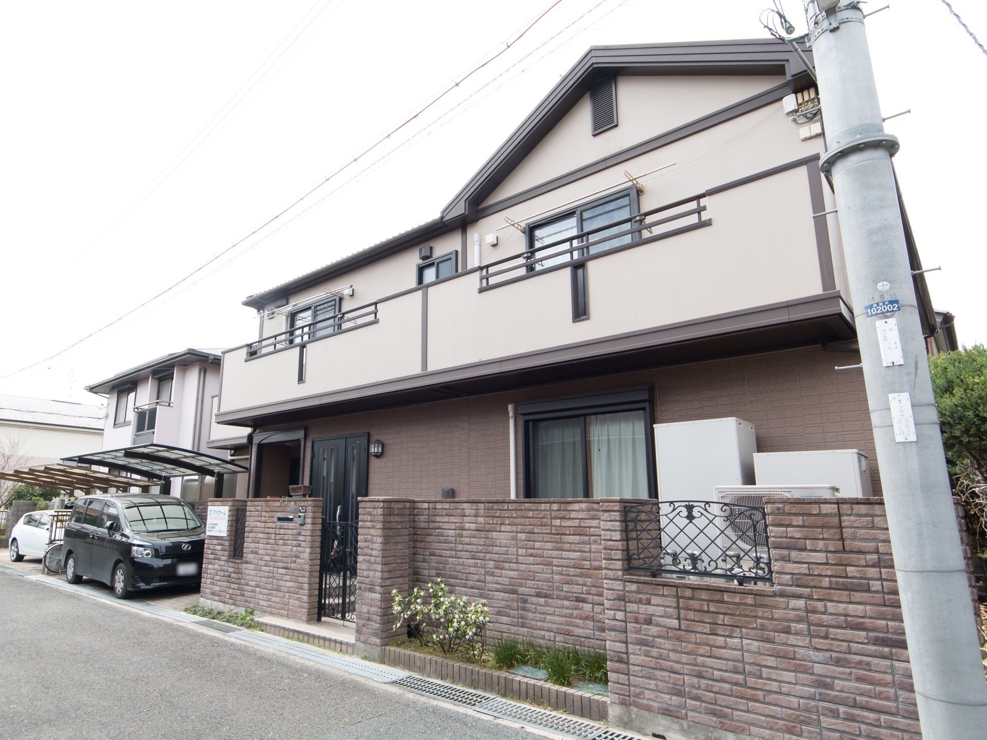 落ち着いた色合いに施された一軒家風の建物である。駐車スペースが設けられており、車が1台停まっている。