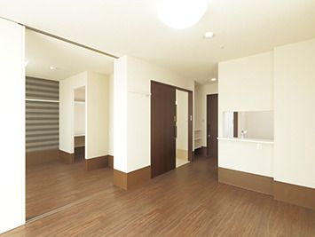 二間続きの比呂居室には家具は付いていない。キッチンにある小窓が見え、トイレのドアが開いている。