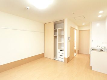 ピクチャーレールが設置されたフローリングの居室にはキッチンや棚、引き出し付きの大型のクローゼットが付いている。