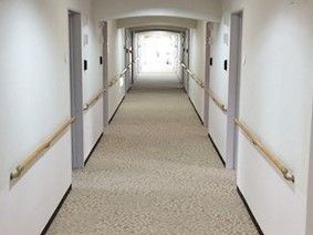 廊下に手すりが取り付けられている。両側のくぼみが個室のドアになっている