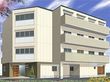 ４階建ての建物の各フロアにベランダが付き、周辺には木や花が植えられている。