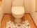 トイレにはＩ型の手すりが付き、花柄のマットやスリッパがセットされている。