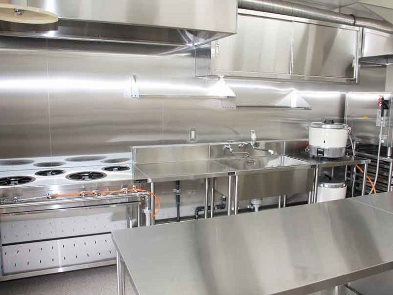 本格的な厨房はステンレス製で清潔にともたれており、大きな炊飯器もある。