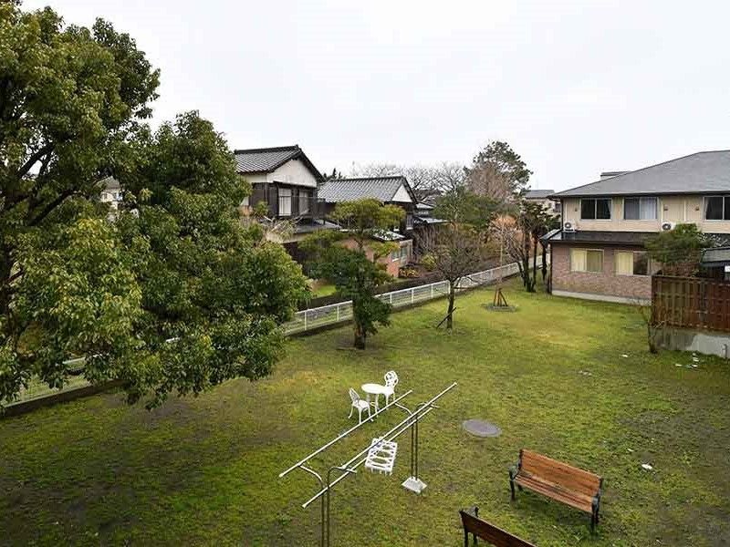 広い庭は大きな木がたくさん植えられ、木製のベンチやテーブルセットが置かれ、洗濯物干し場もある。