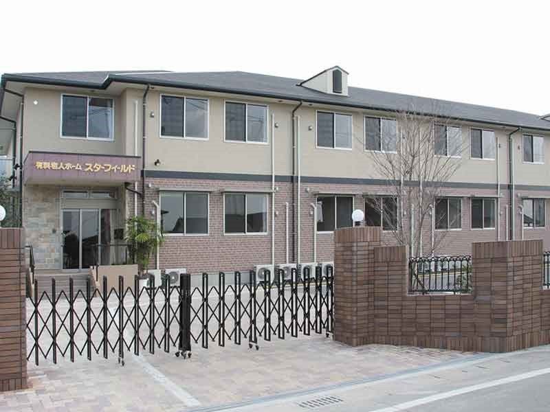 ２階建ての建物。ブラウンを基調とし、出入り口には屋根が付き、門は閉められている。