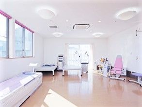 大きな窓がたくさんついた明るいリハビリスペース。各種リハビリ機器がそろっている。