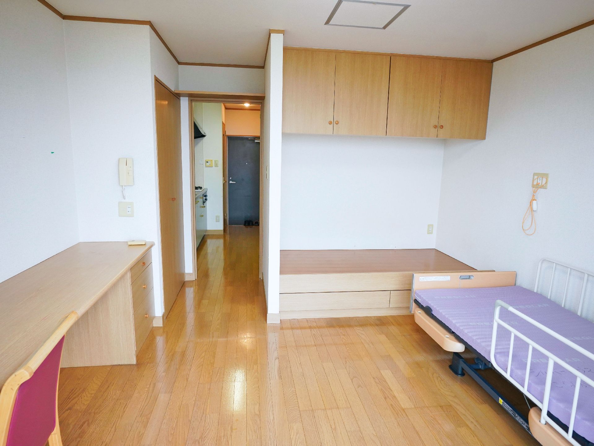 窓から日差しが入り、備え付けの介護ベッドなどがある居室