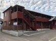 ブラウン系の２階からの建物の外壁にはホーム名が書かれた看板があり、屋外階段も設置されている。