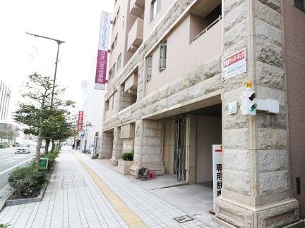 道路に面した建物はベージュで重厚感ああり、1階部分には駐車場もある。