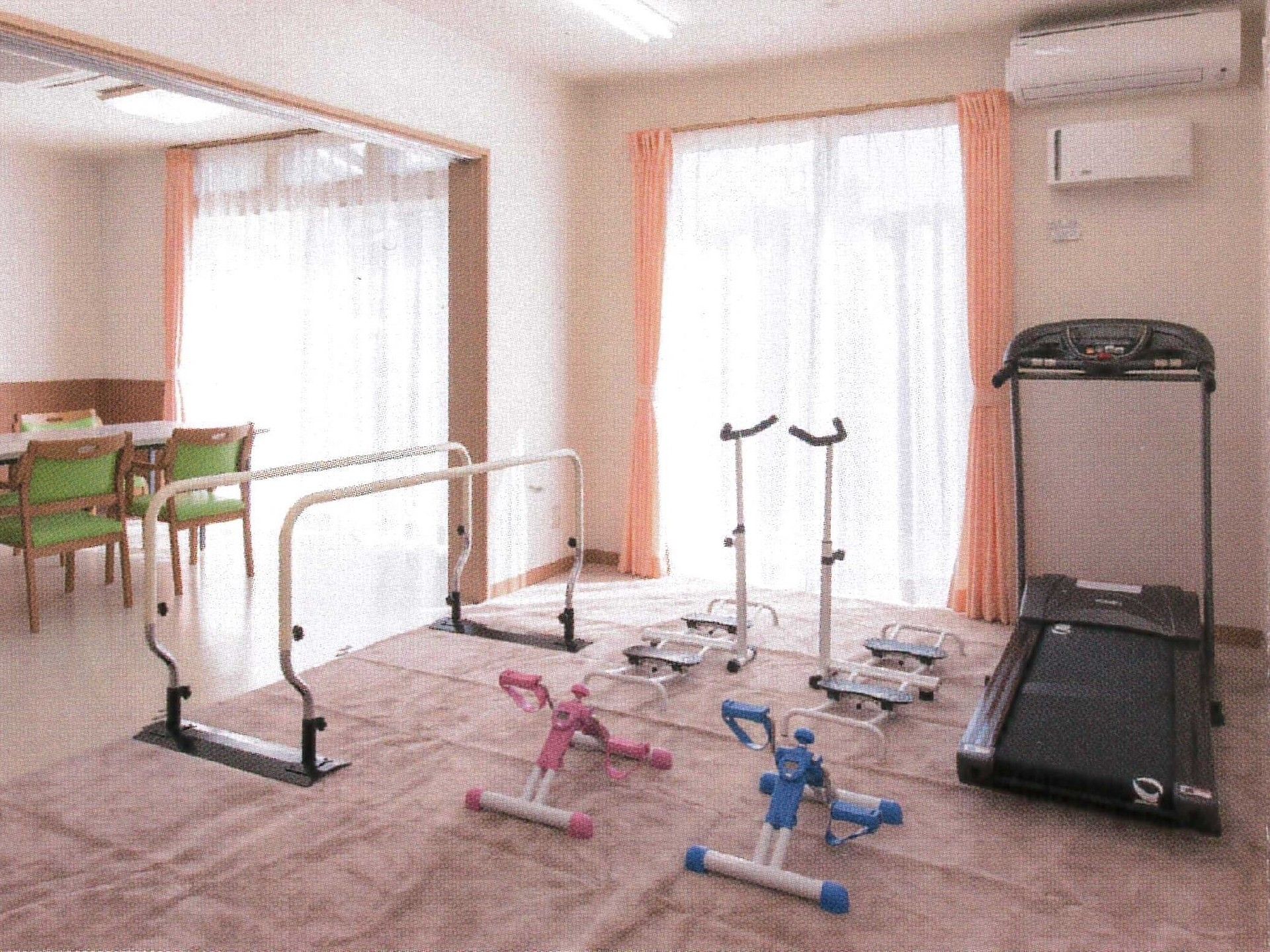 デイサービスセンターの中央にはカーペットが敷かれ、トレーニング機器が置かれている。