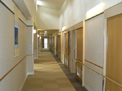まっすぐな廊下は明るく、右サイドに居室のドアが並んでいる。手すりを設置し安全な設計。