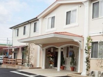 洋風デザインが印象的な２階建ての建物の写真。エントランスに雨除けのひさしが付いている