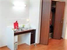 居室内の洗面台と収納スペースを写した写真。小さな個室内の設備