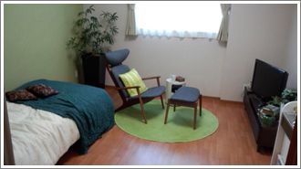 モダンなデザインの家具がならぶ小さな部屋。ベッドと感じの良い家具類が並んでいる様子