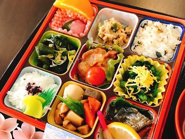 ９つのマスに分かれたお弁当のような食事の写真。色とりどりのおかずが並んでいる