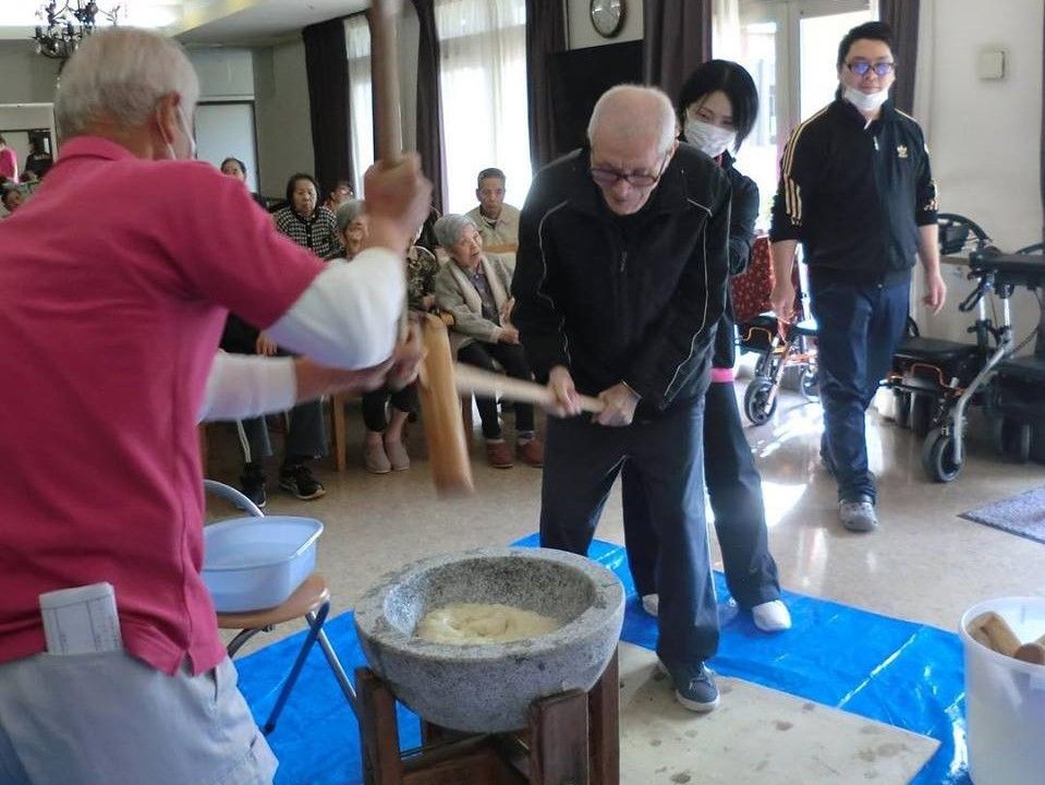 餅つきをしている高齢者とスタッフの様子。お正月の餅つきイベント時の写真