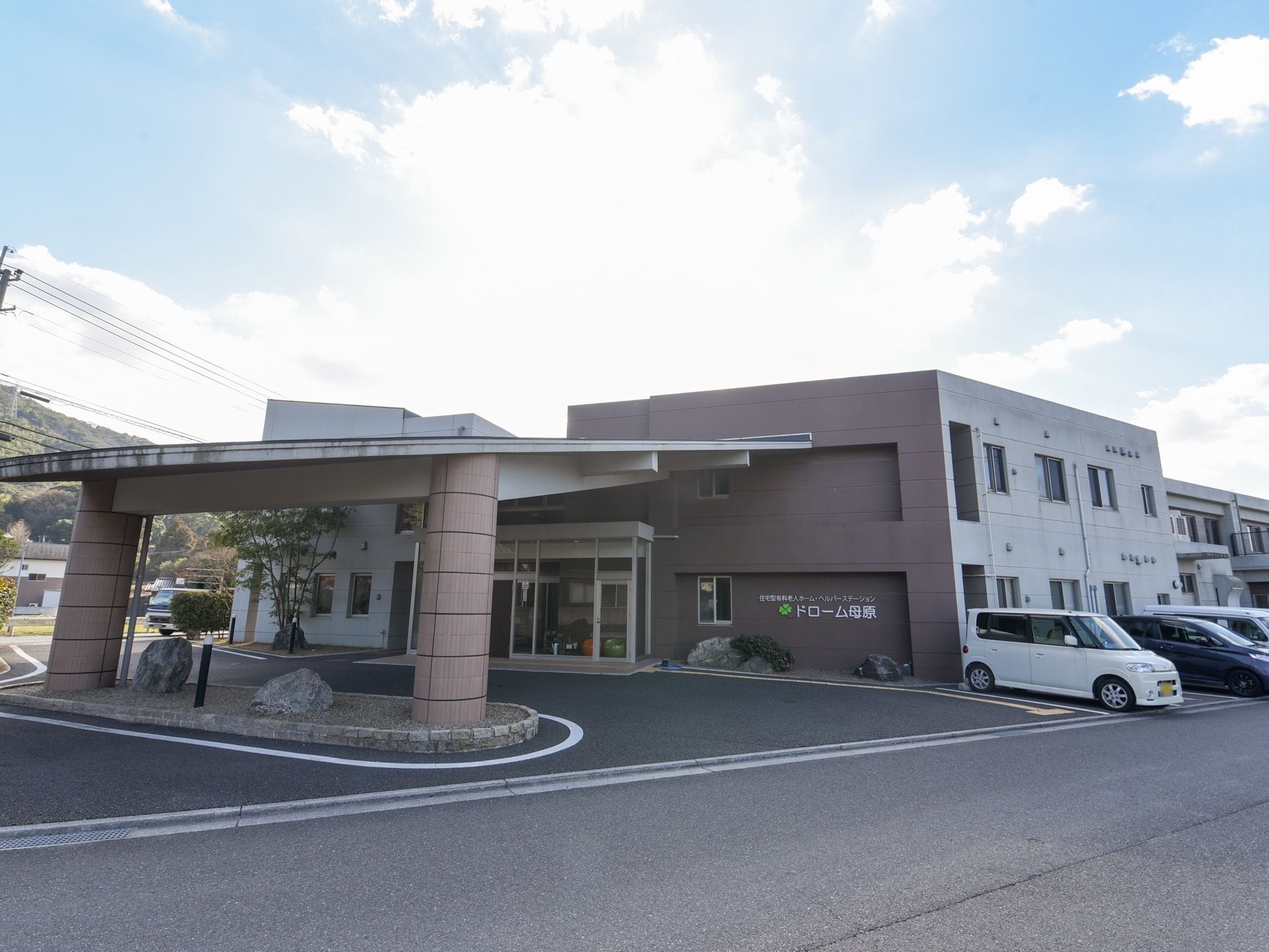 玄関に設けられた大きな車寄せが特徴的である。玄関の右側の外壁に、大きな文字で施設名称が表示されている。