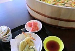 寿司桶に入ったちらし寿司とさらに盛り付けられた天ぷら