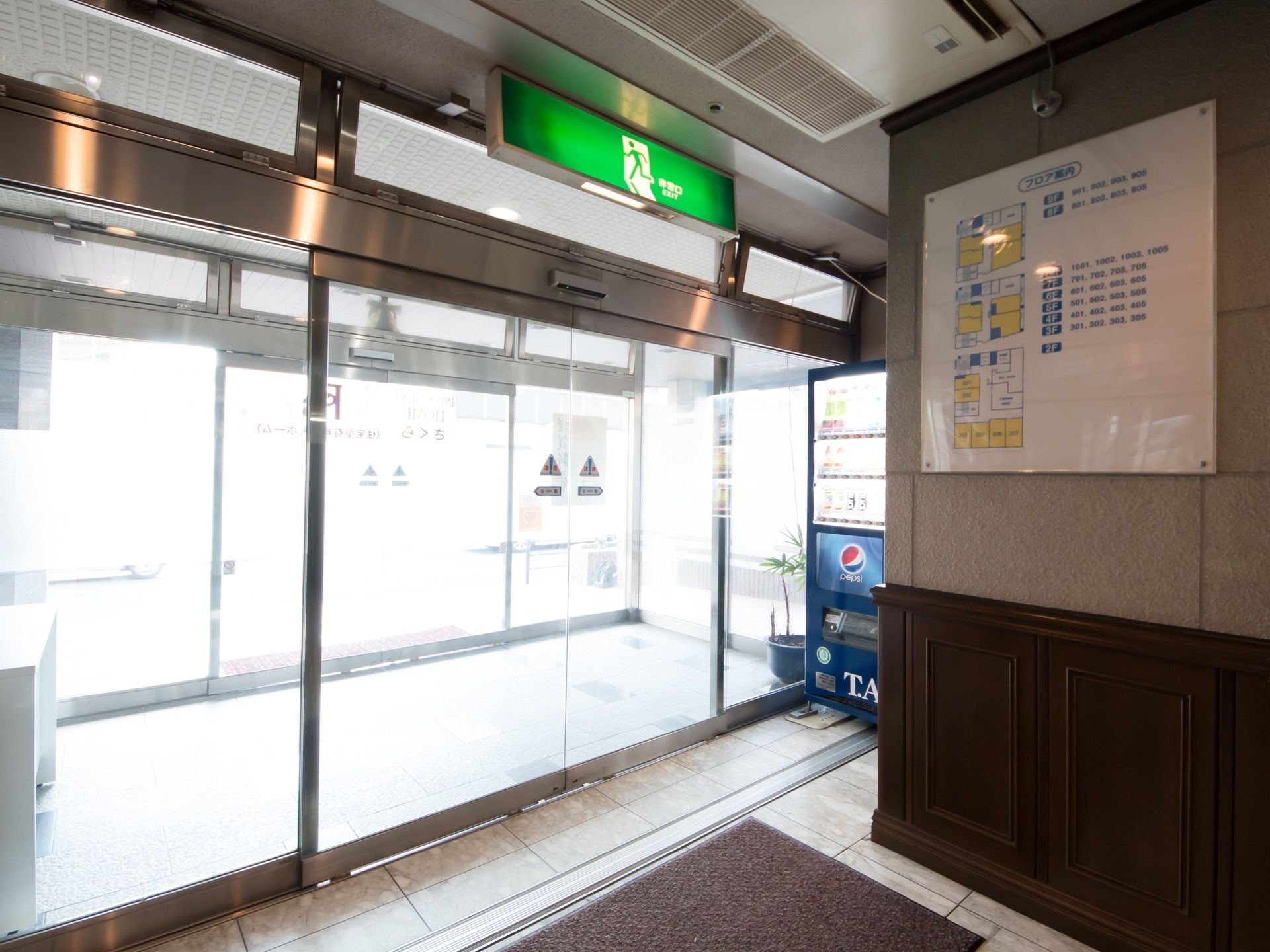 玄関は２重構造になっている。内側の自動扉を入ってすぐの所に館内案内が掲示されている。その横には飲料の自動販売機がある。