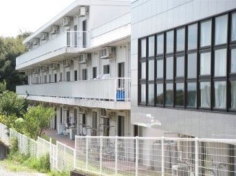 鉄骨造の建物の外観写真。ケアハウス秀照庵 を中庭から写した様子