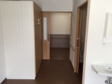 車いす対応の洗面所やトイレが付いたフローリングの部屋の出入り口にはスライド式のドアが設置されている。