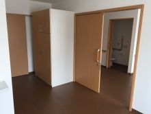 大きなクローゼットが付いたフローリングの部屋にはスライド式のドアが設置され、向かいの居室内も見える。