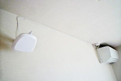 ブラウンの手すりを付けた白を基調とした一人用の浴槽が設置された浴室には、オレンジのシャワーチェアもある。