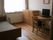 介護ベッドやチェスト、デスクセットなどが置かれているフローリングの部屋には大きな窓が付いている。