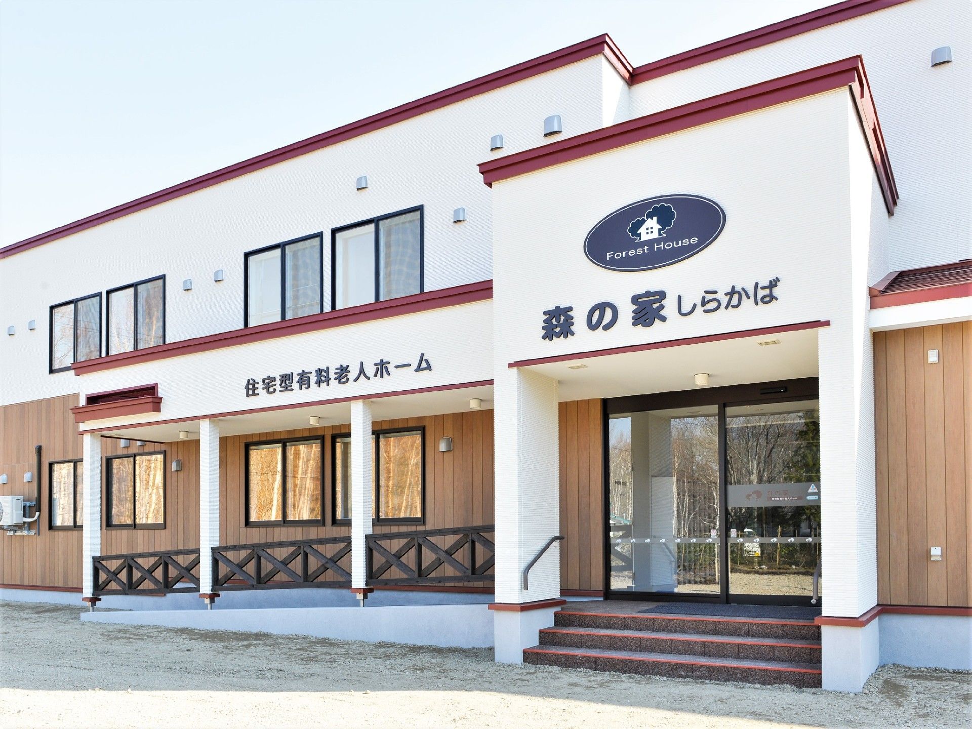 赤いラインが印象的な施設の外観。テラスやスロープがある玄関付近