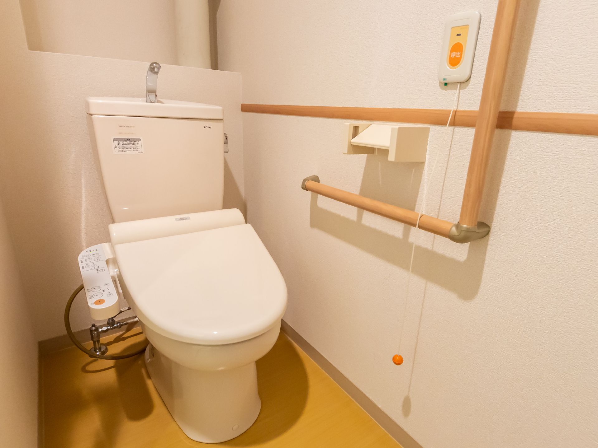 バリアフリー完備で、壁に手すりが設置されているトイレ