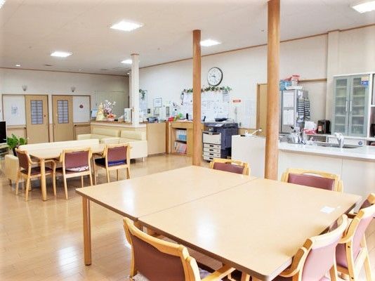 複数のダイニングテーブルが並んだリビングには大きなテレビや時計も付き、対面式キッチンもある。
