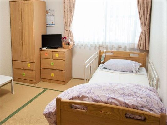 木製のクローゼットとタンス、介護用ベッドなどが付いた畳敷きの和室には大きな窓が付いている。