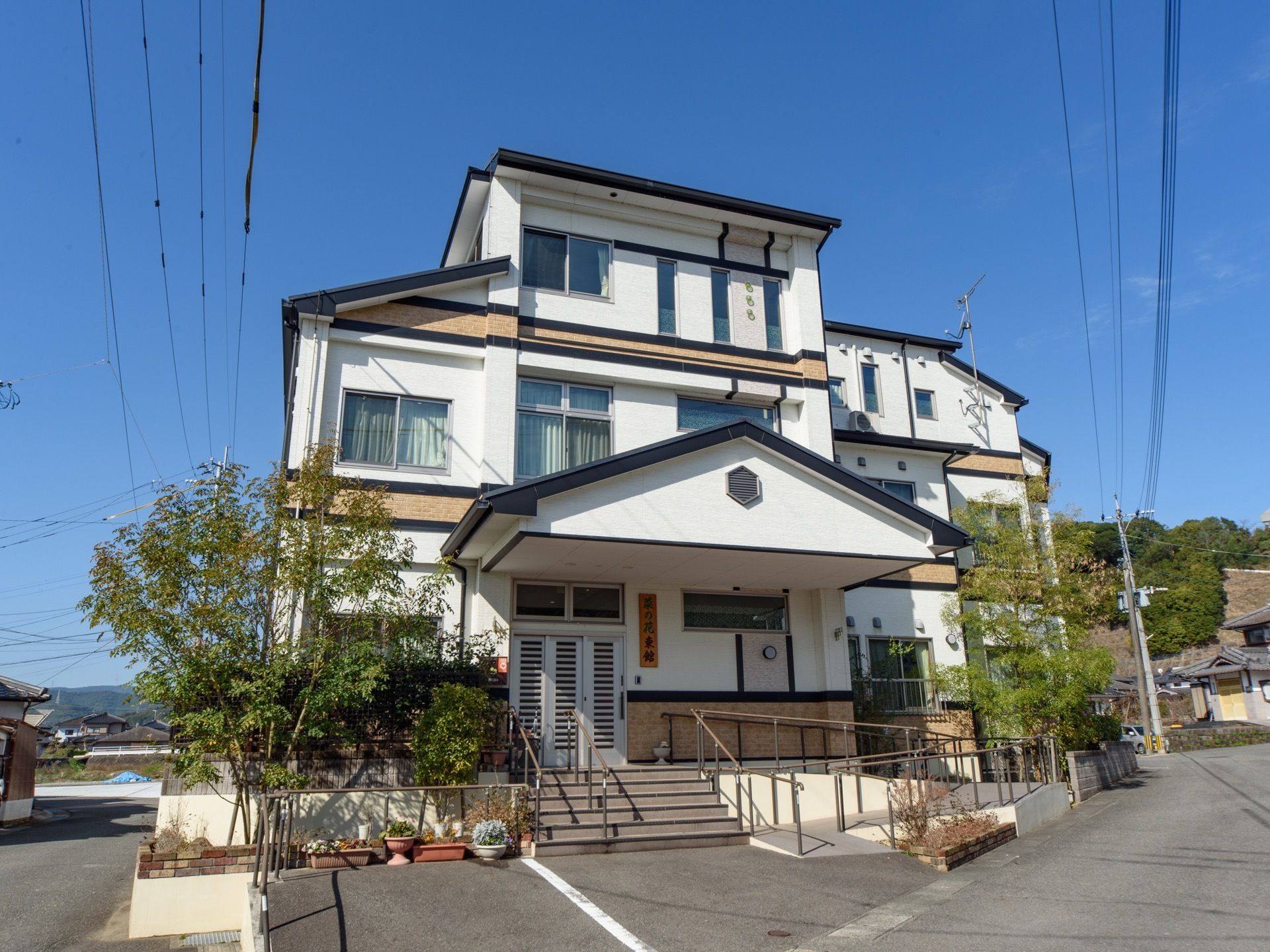 施設は、豊かな自然のある閑静な住宅街に位置している。住宅街に馴染みやすい外観の戸建てで、建物前には駐車場がある。