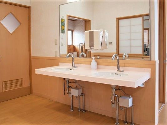 大きな鏡が付いた洗面所。洗面所が二つ並び、足元のスペースが開いている。
