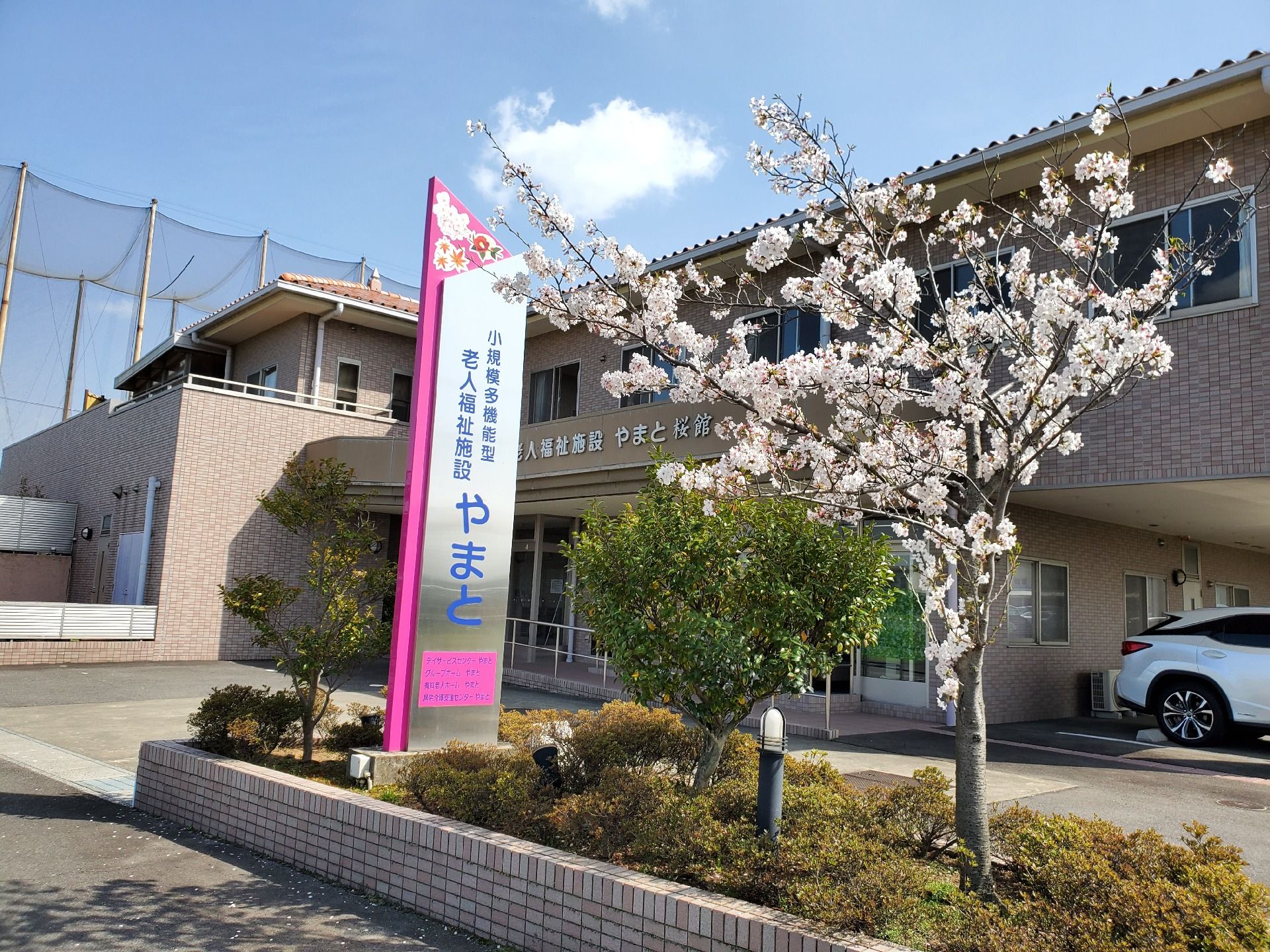 ベージュのソファを囲んでしゃべっている高齢女性たち。白衣を着た女性スタッフも加わっている。
