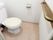 シンプルなトイレ。便器の正面には手すりが付き、しっかりと握ることができる。