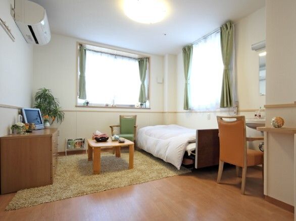 施設内の一人用の居室の様子。調度品と介護用ベッドなどが置かれている様子