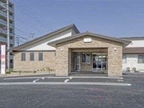 ベージュと白の外壁で三角屋根の平屋建て住宅型有料老人ホーム