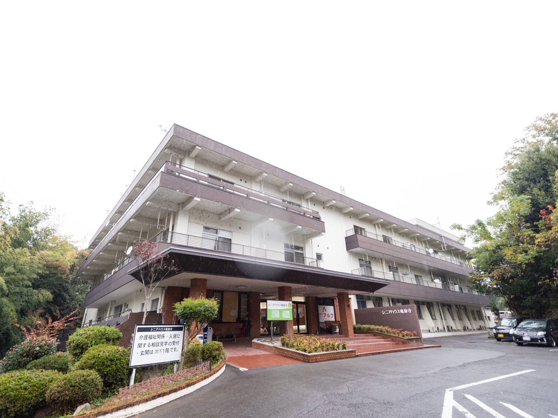 旅館風の３階建ての施設である。白い壁にグレーの屋根が乗っている。玄関ポーチはレンガで構成されている。