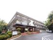 旅館風の３階建ての施設である。白い壁にグレーの屋根が乗っている。玄関ポーチはレンガで構成されている。