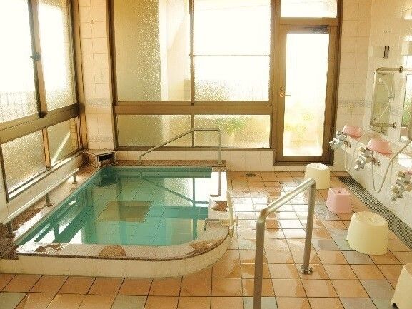 日当たりのいい場所に建っている大きな建物はブラウン系の外壁でグリーンの屋根が付いている。