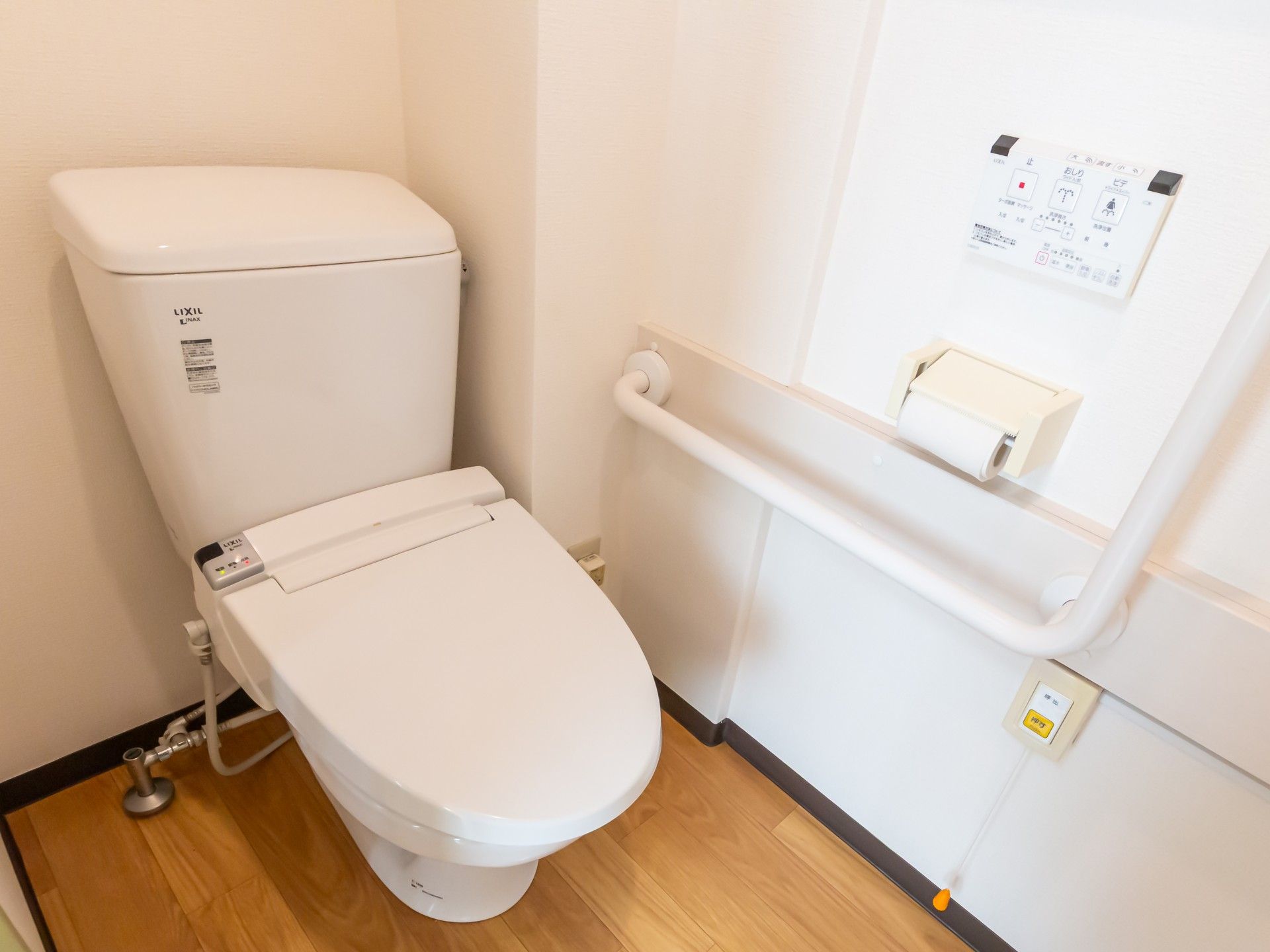 カメラに向かって笑顔を見せるスタッフと高齢者の女性。施設での何気ない一場面の様子